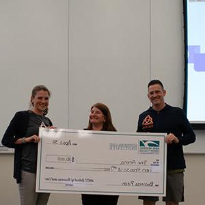 The Arena pitchers holding a large check with Stephanie Goldenberg